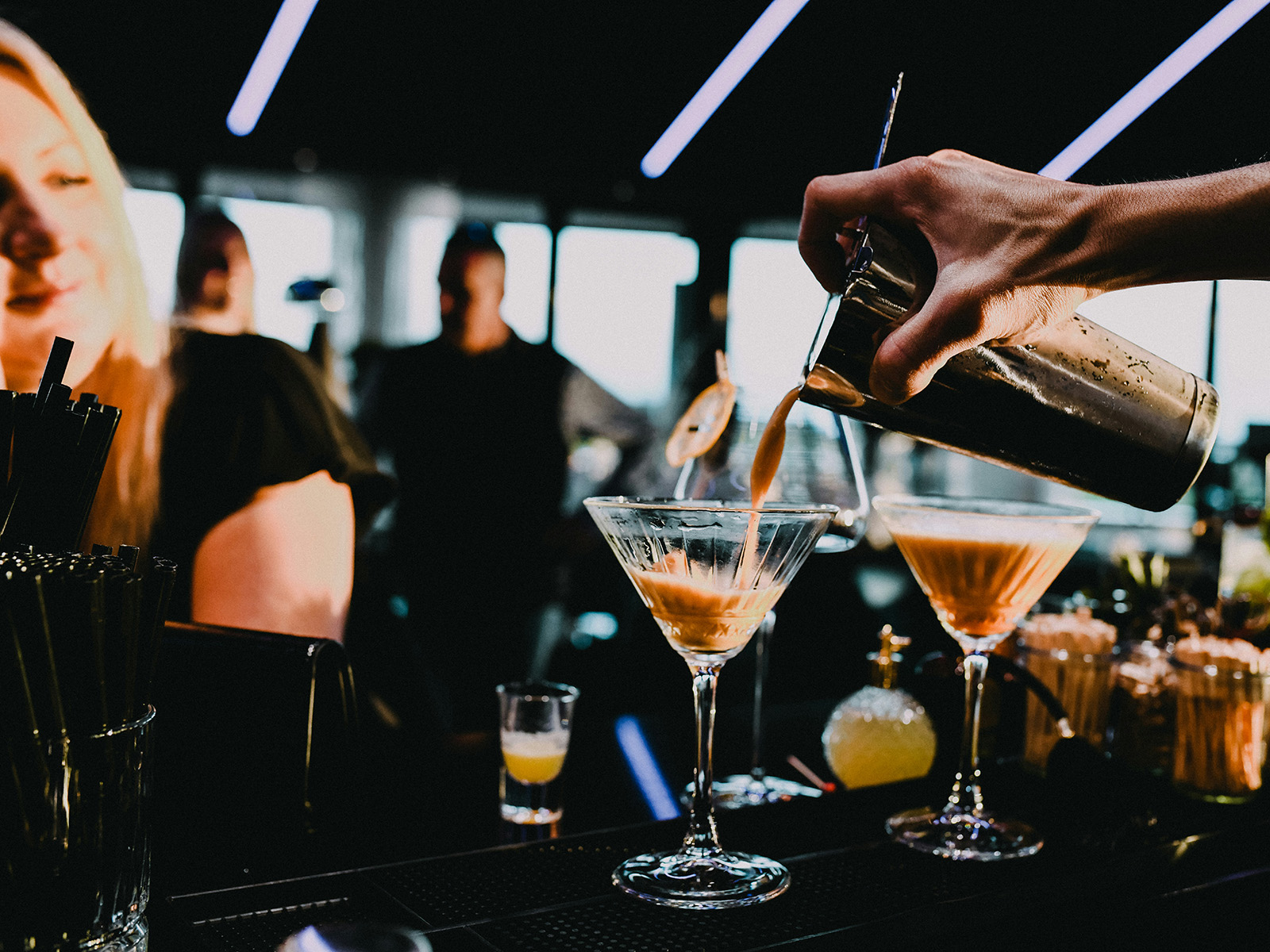 Energetic, crowded bar or brewery taproom at peak hour with bartenders making drinks