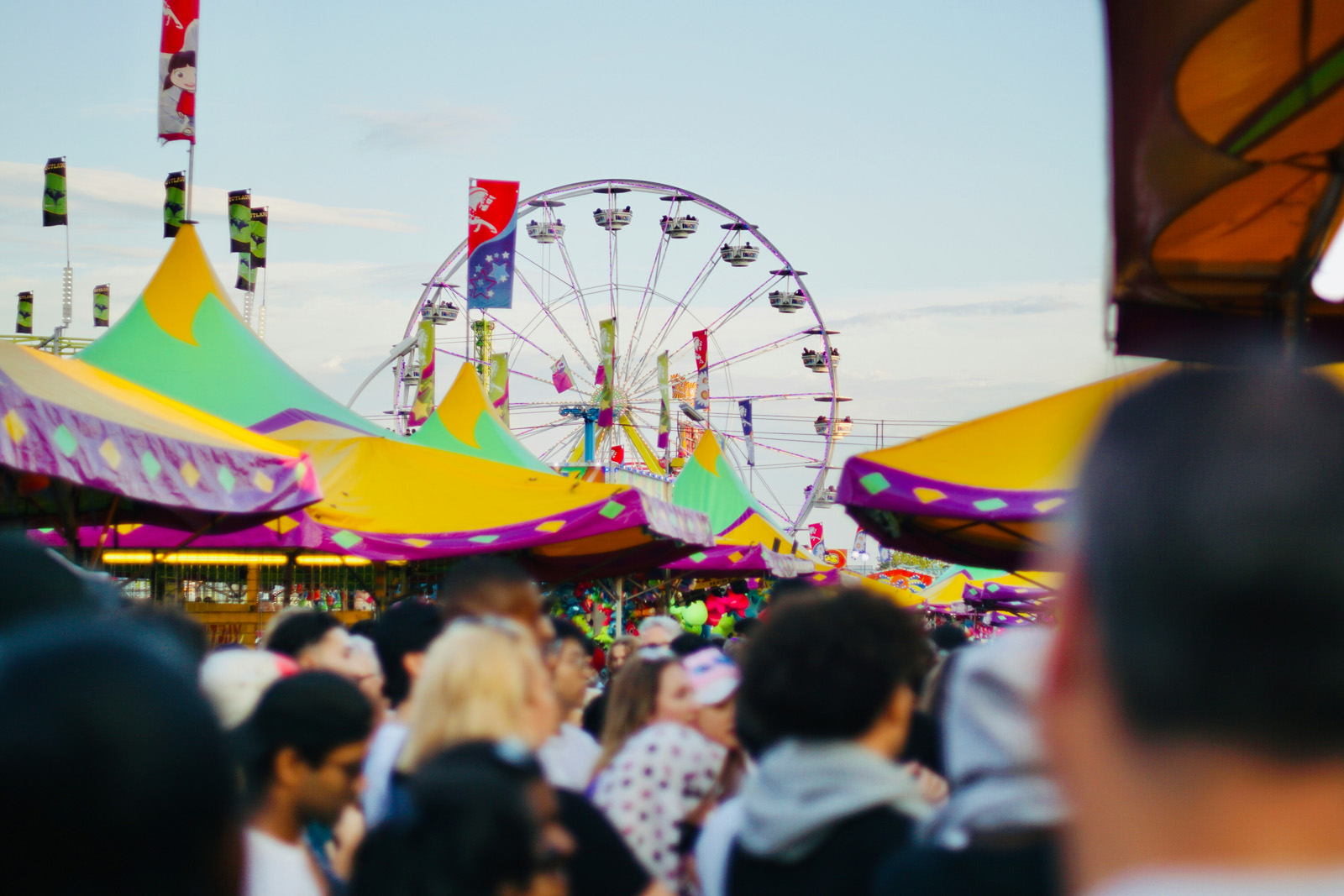 Families entering an amusement and water park, scanning wristbands and tickets at the front gate on a sunny day