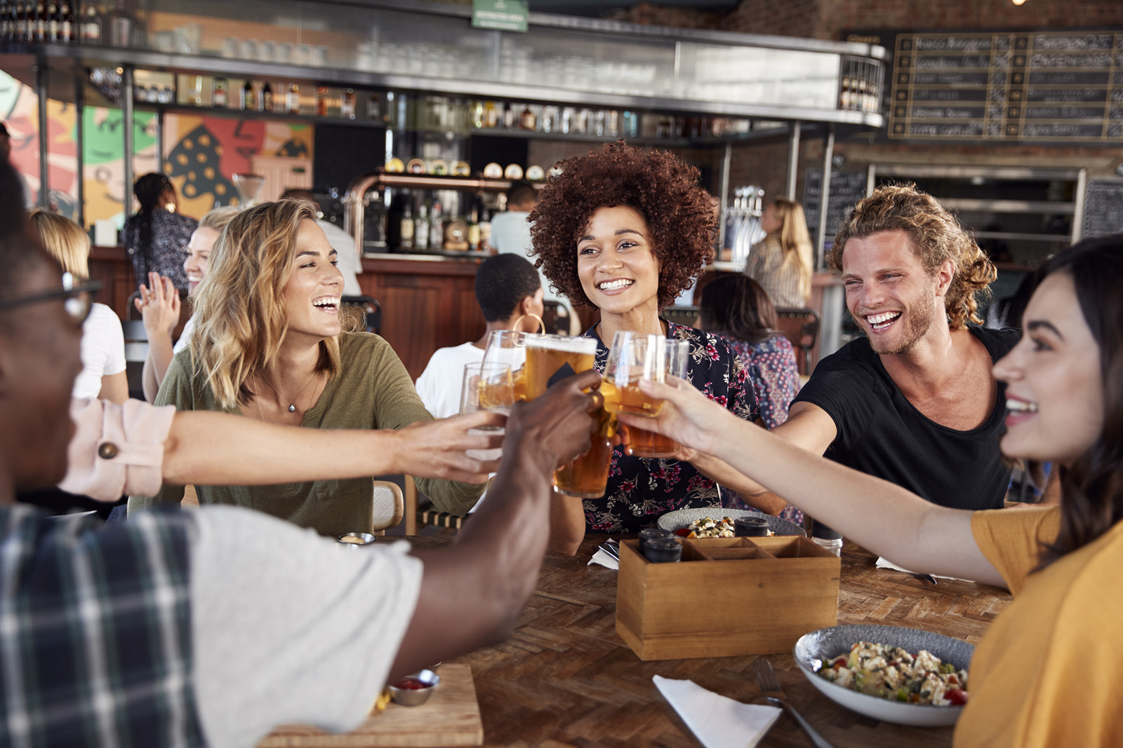 Guests enjoying a featured drink special; could show a phone with a drink offer