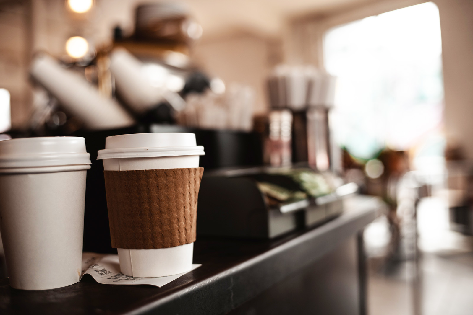An order-ahead pickup shelf with labeled cups, or a phone showing a cafe app order ready for pickup