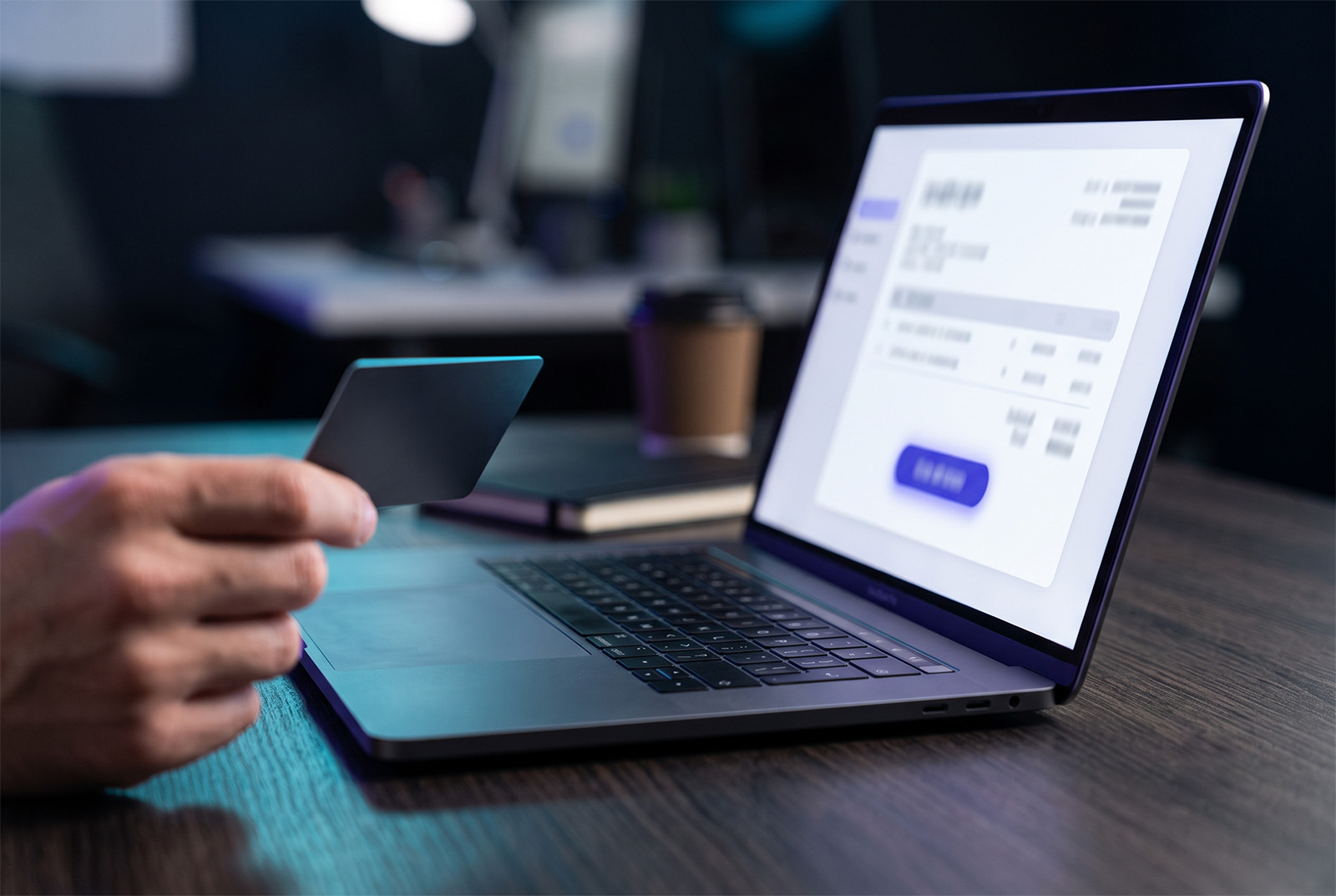 Laptop showing an emailed invoice with a secure pay link and a corporate card in hand