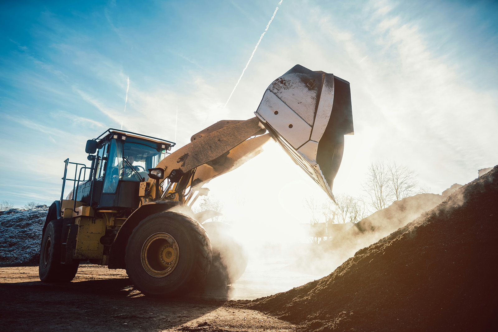 Rental yard at golden hour with lifts and equipment staged in rows