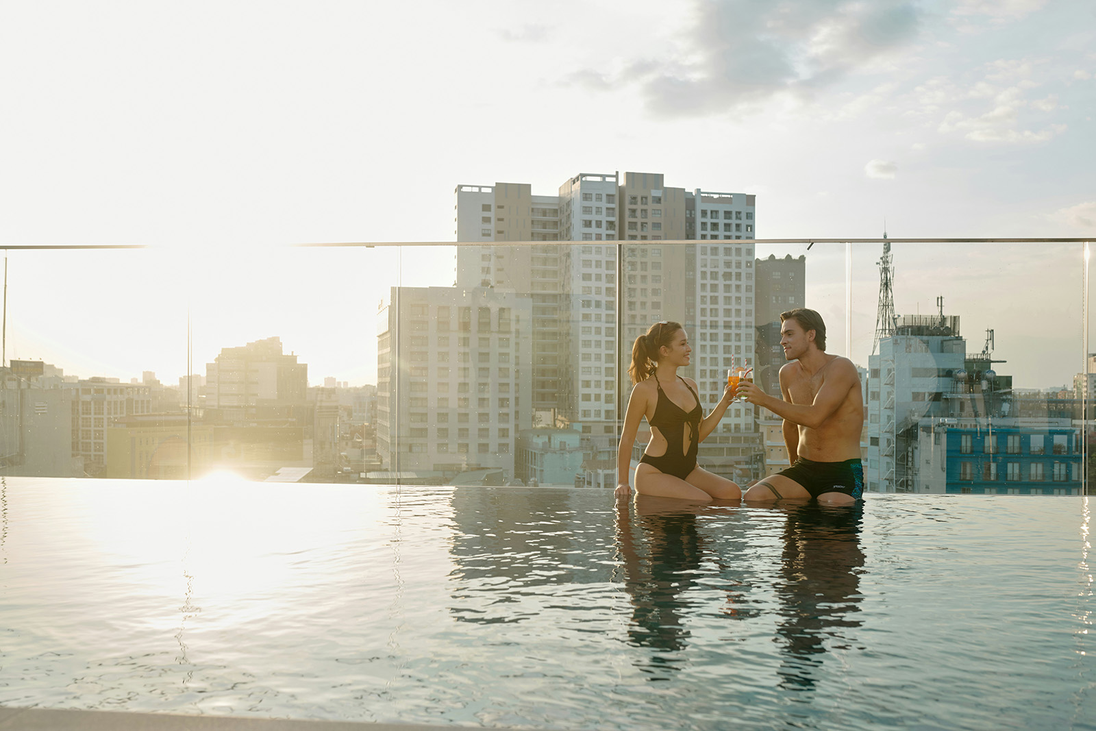 A hotel rooftop bar at golden hour or an in-room dining setup; aspirational hospitality