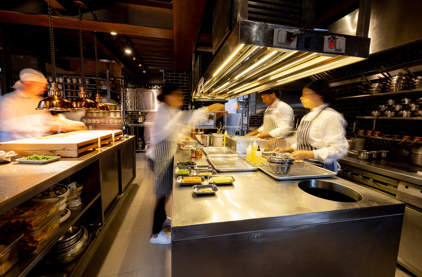 A kitchen line working from a single consolidated order screen; calm and efficient