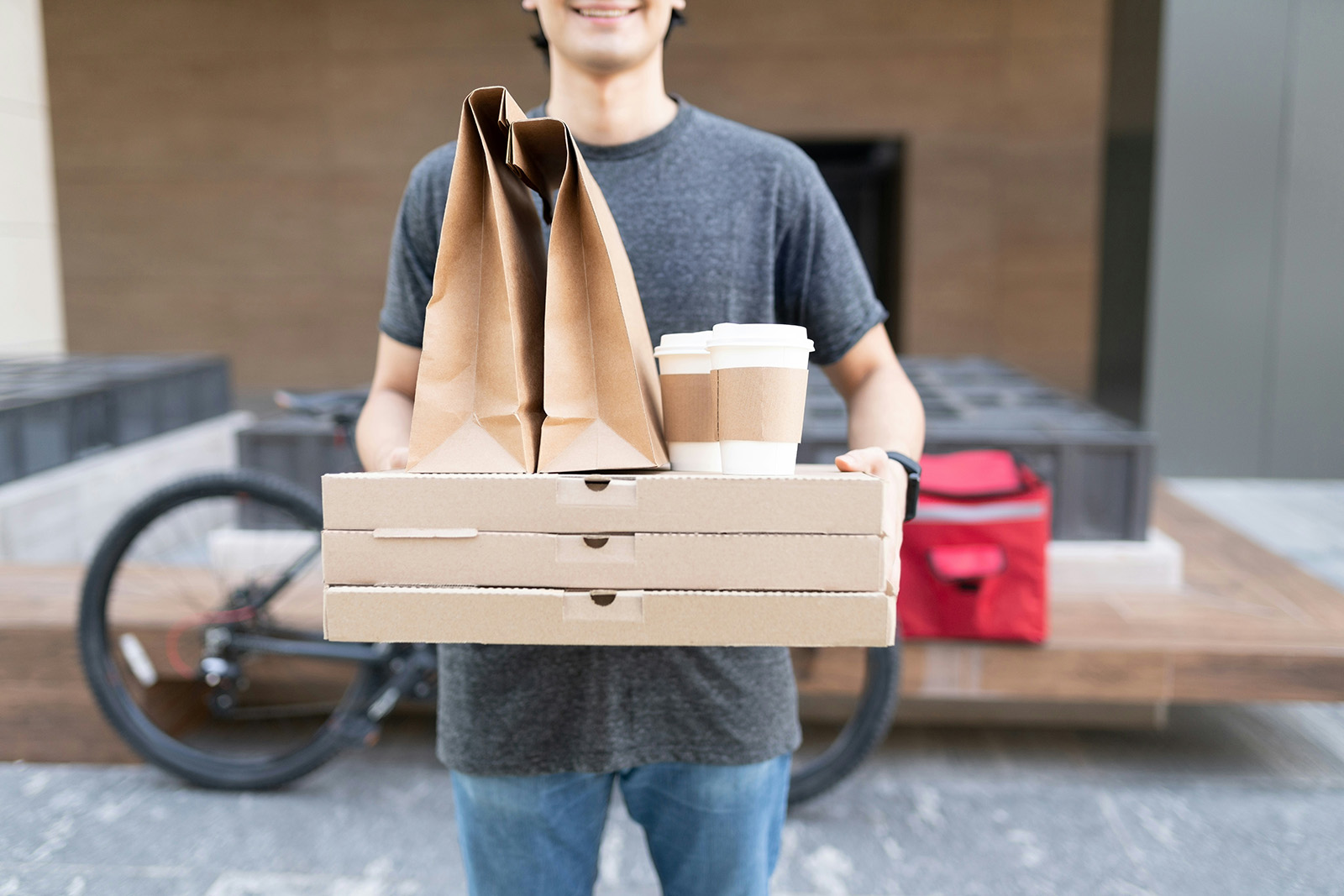 A delivery handoff or a phone placing a food order; modern, convenient, appetizing