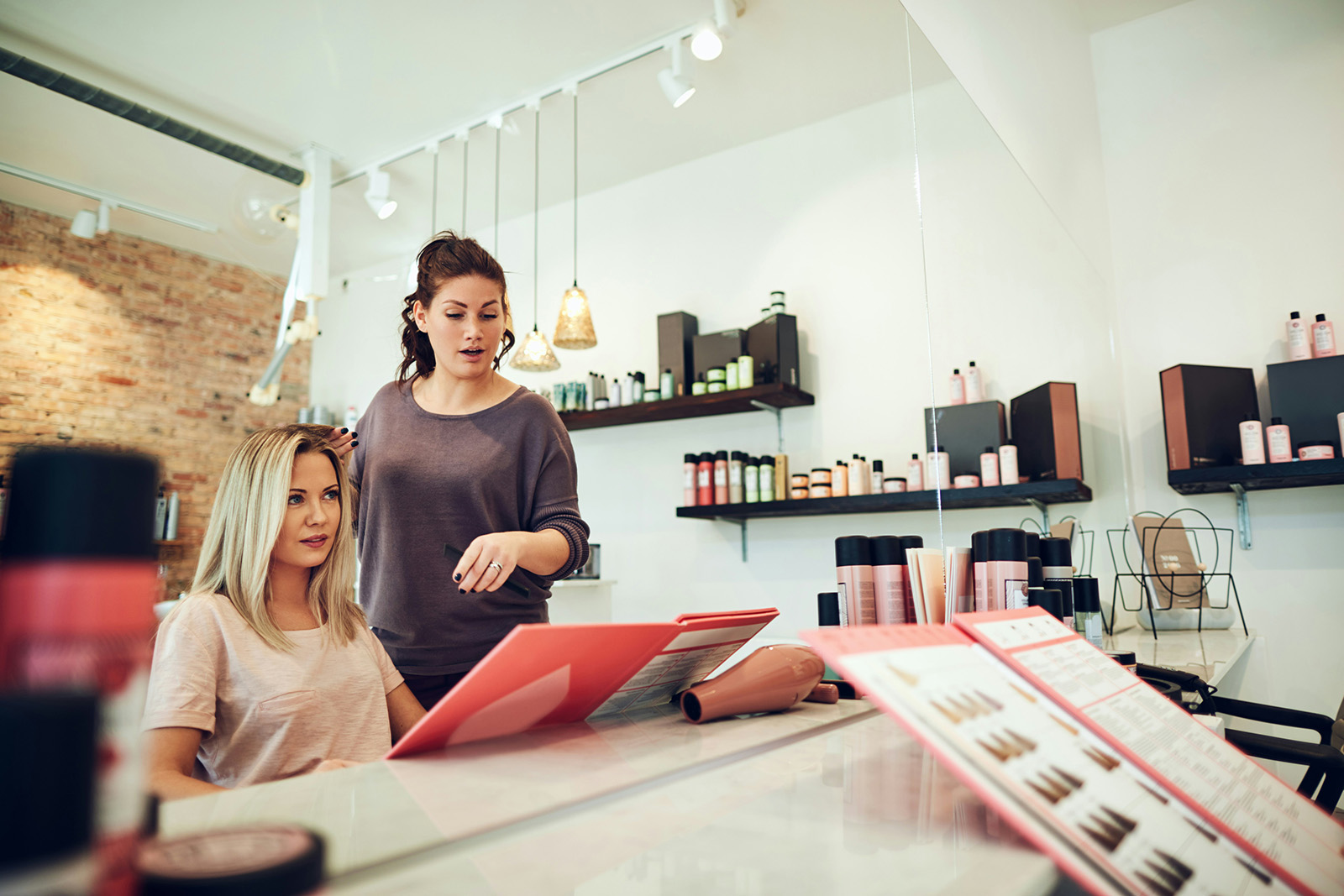 Modern, calm salon or spa reception; a stylist checking out a client