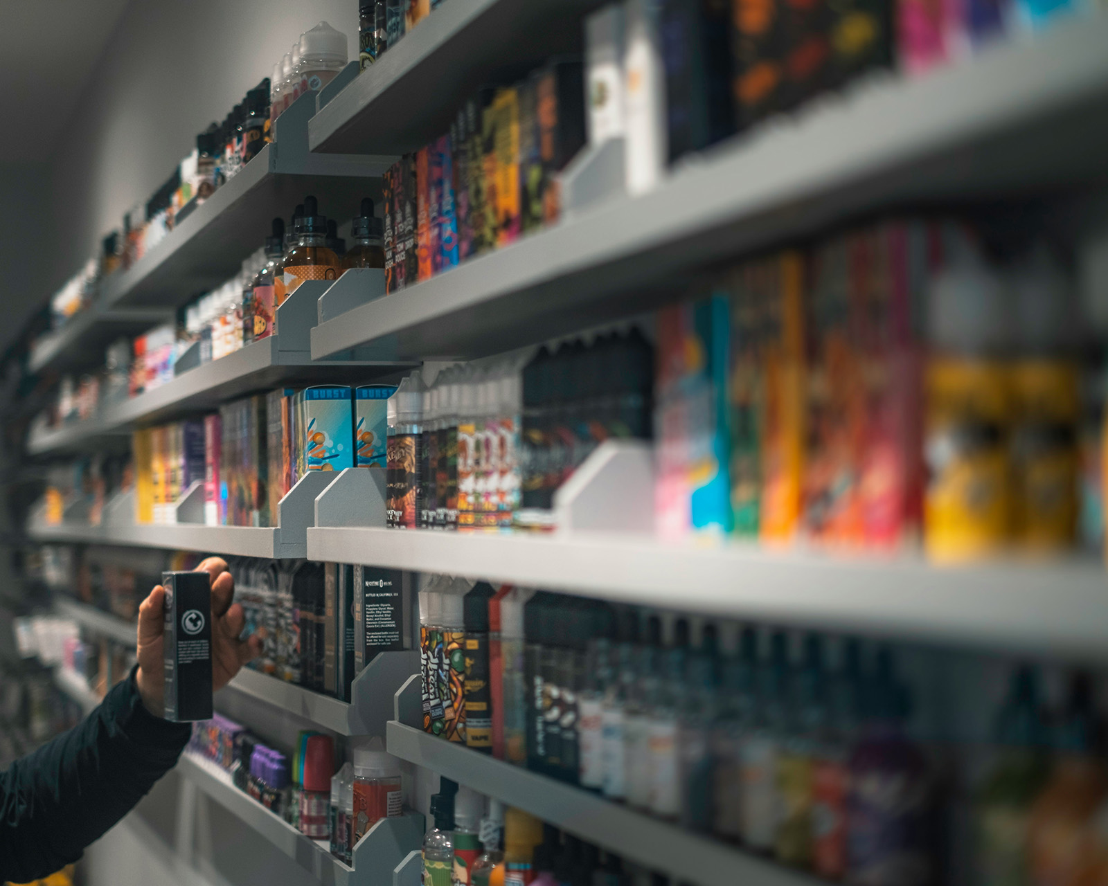 A wall of vape and smoke products organized by variant, or a tablet inventory count among the shelves