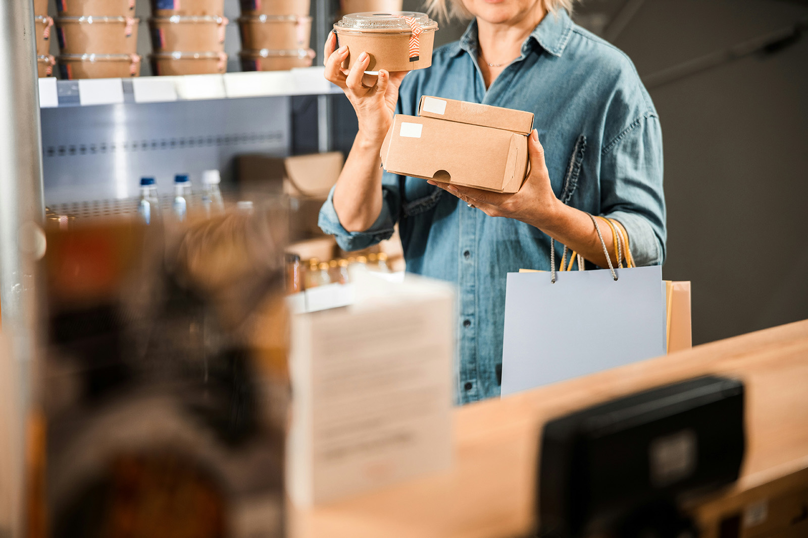 A kitchen prepping delivery orders with branded bags; busy and entrepreneurial
